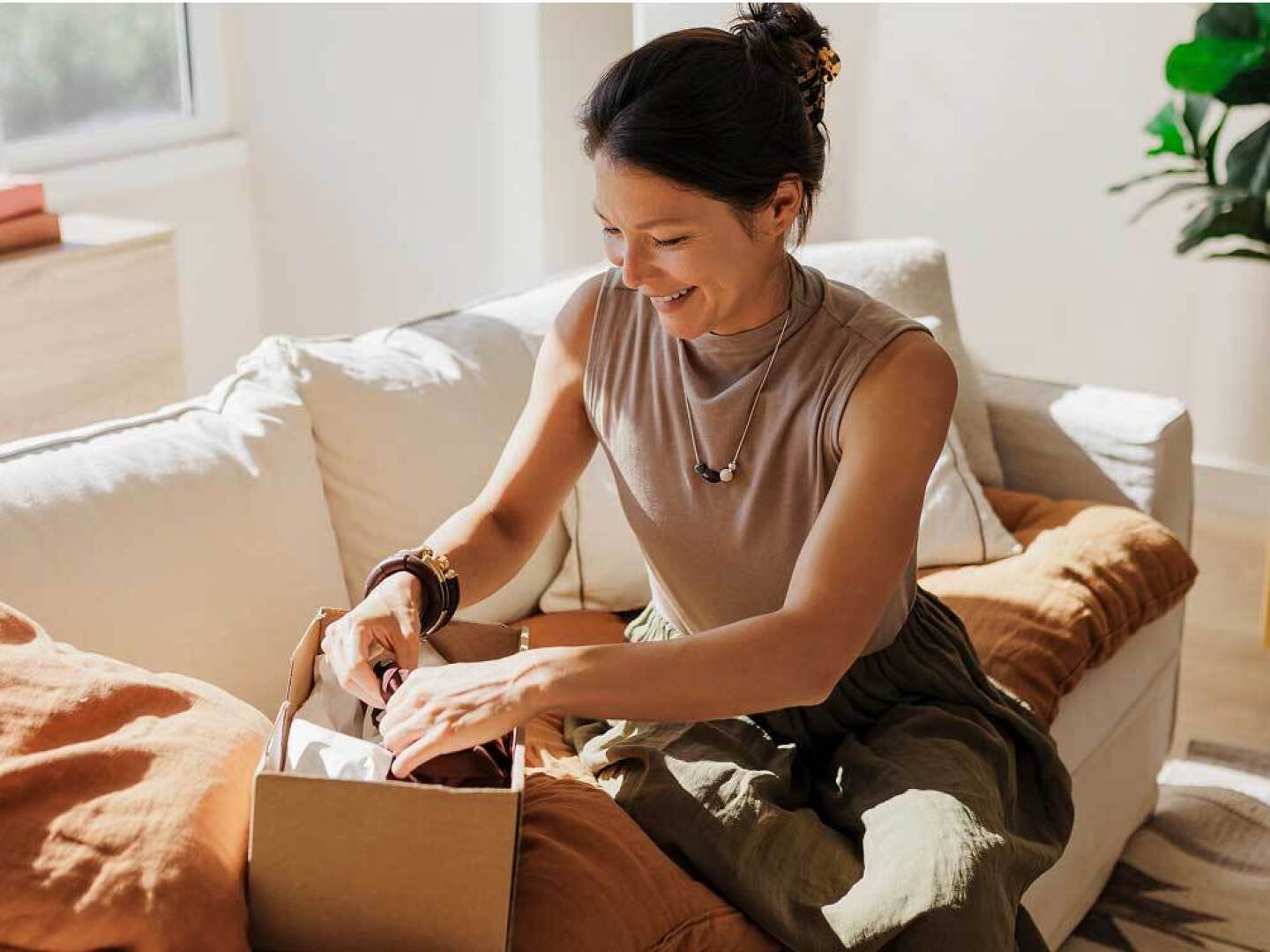 Woman in sleeveless shirt take product out of cardboard box