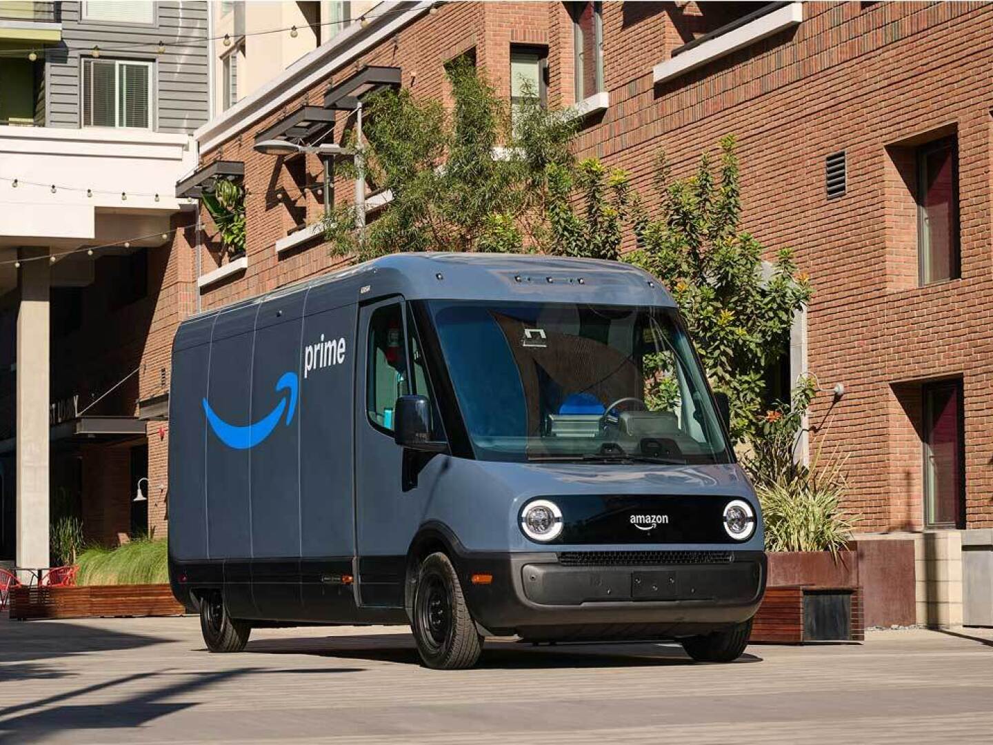 image of Amazon prime shipping van in front of a brick building